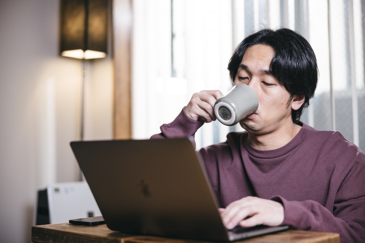 眠そうにコーヒーを飲む人