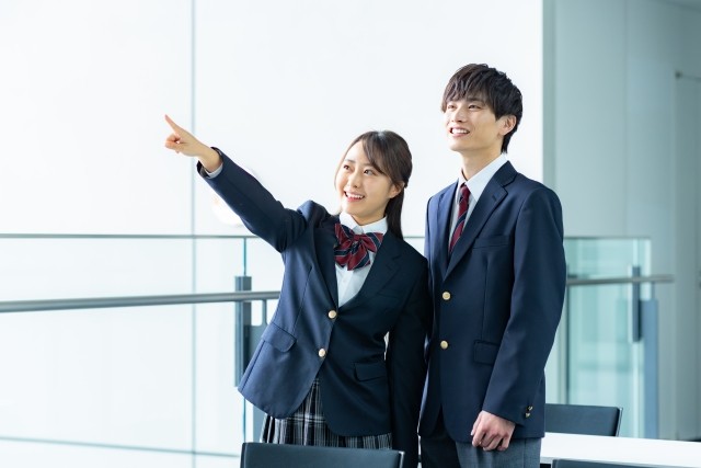 先を指さす明るい女子生徒と男子生徒