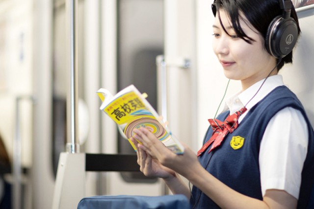 通学電車の中で勉強する女子高生